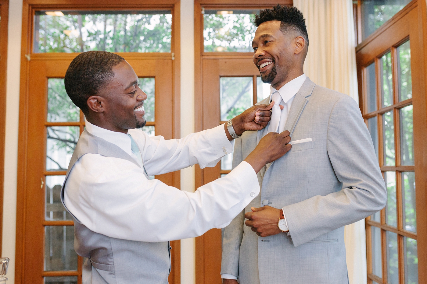 best man helping groom get ready in atlanta wedding