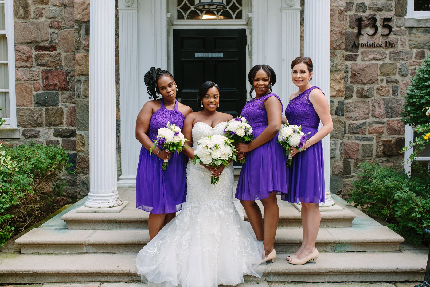 brides wearing short purple dresses with white bouquets