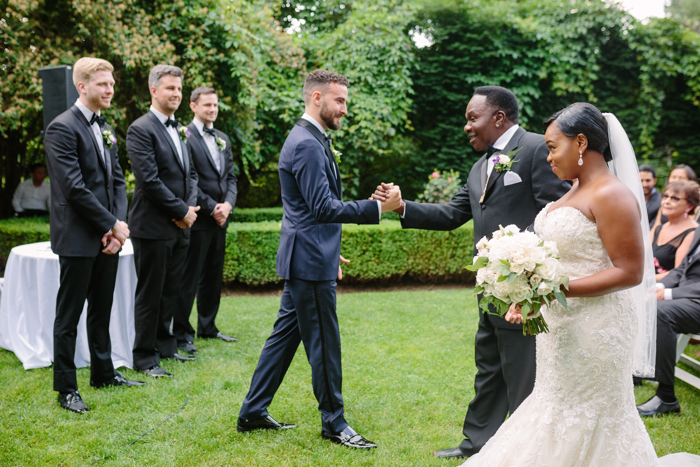 groom shaking hands with father of the bride at wedding ceremony