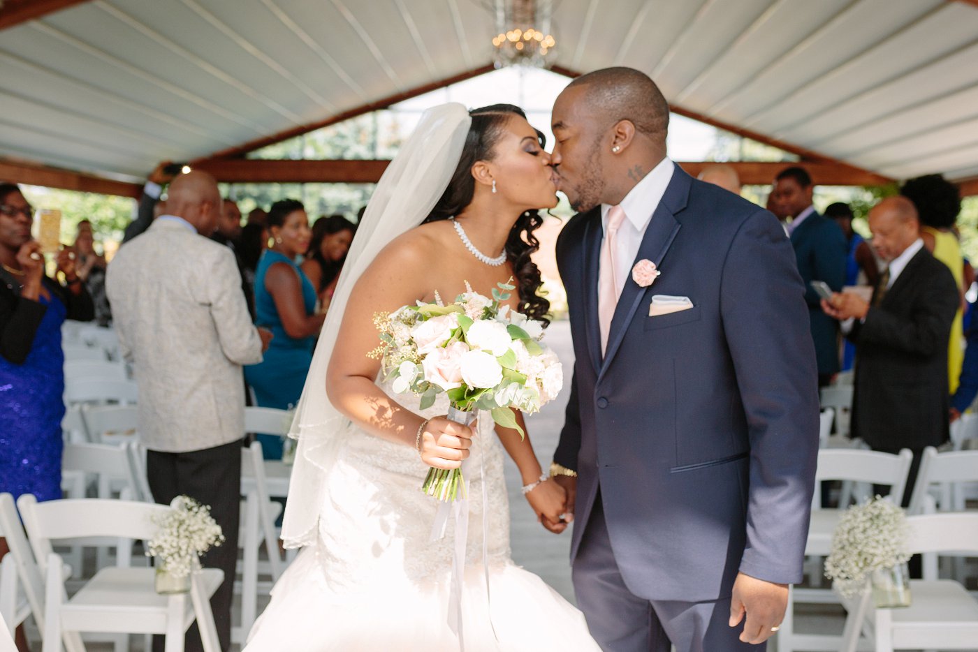 bride and groom kiss after wedding ceremony