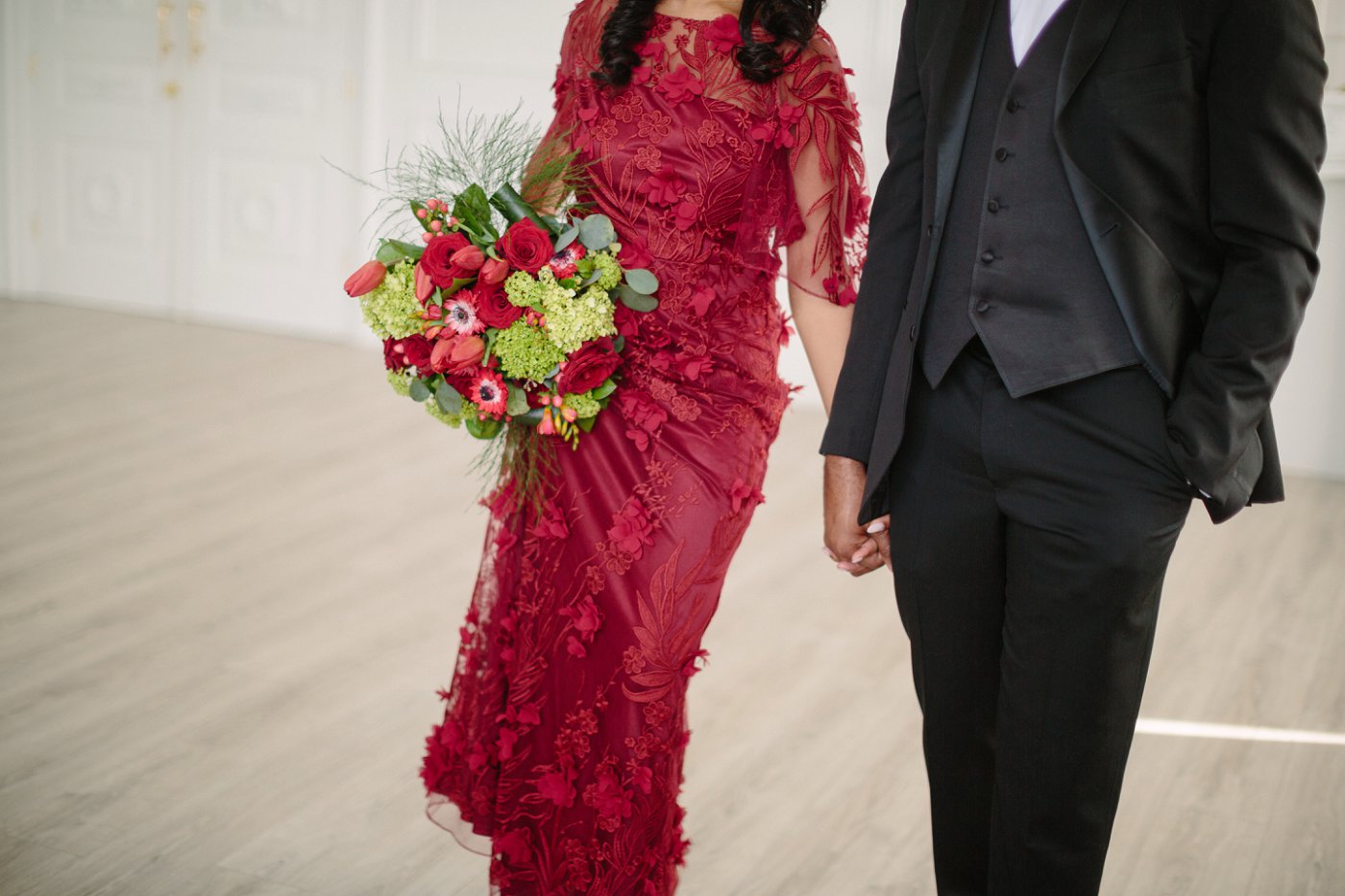 floral arrangement with red gown and black tuxedo