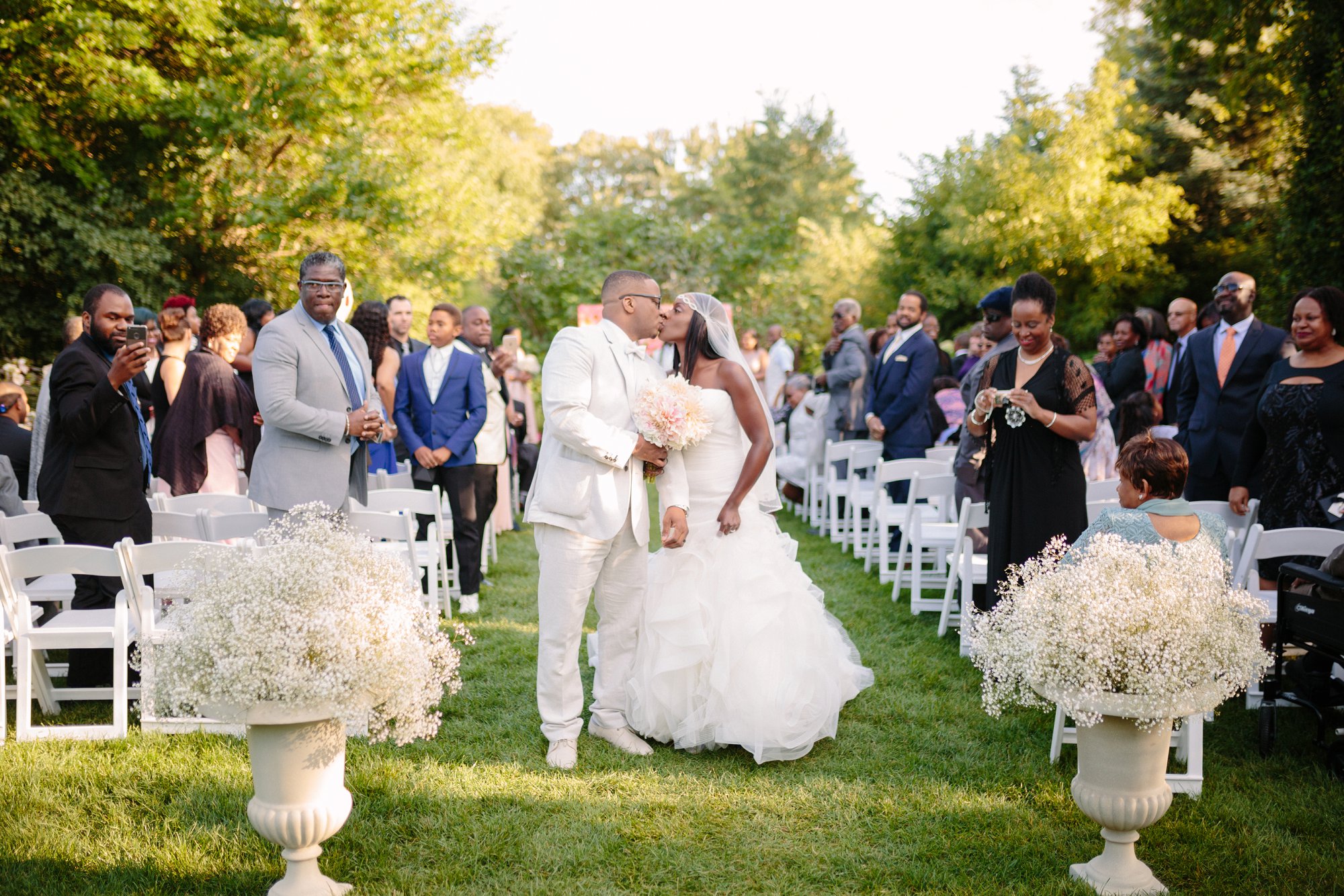 Bride and groom kiss at outdoor wedding ceremony at graydon hall manor