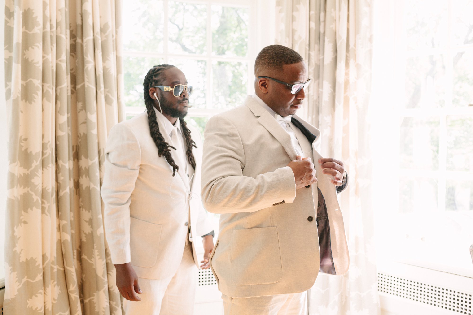 groom getting ready with help of groomsmen
