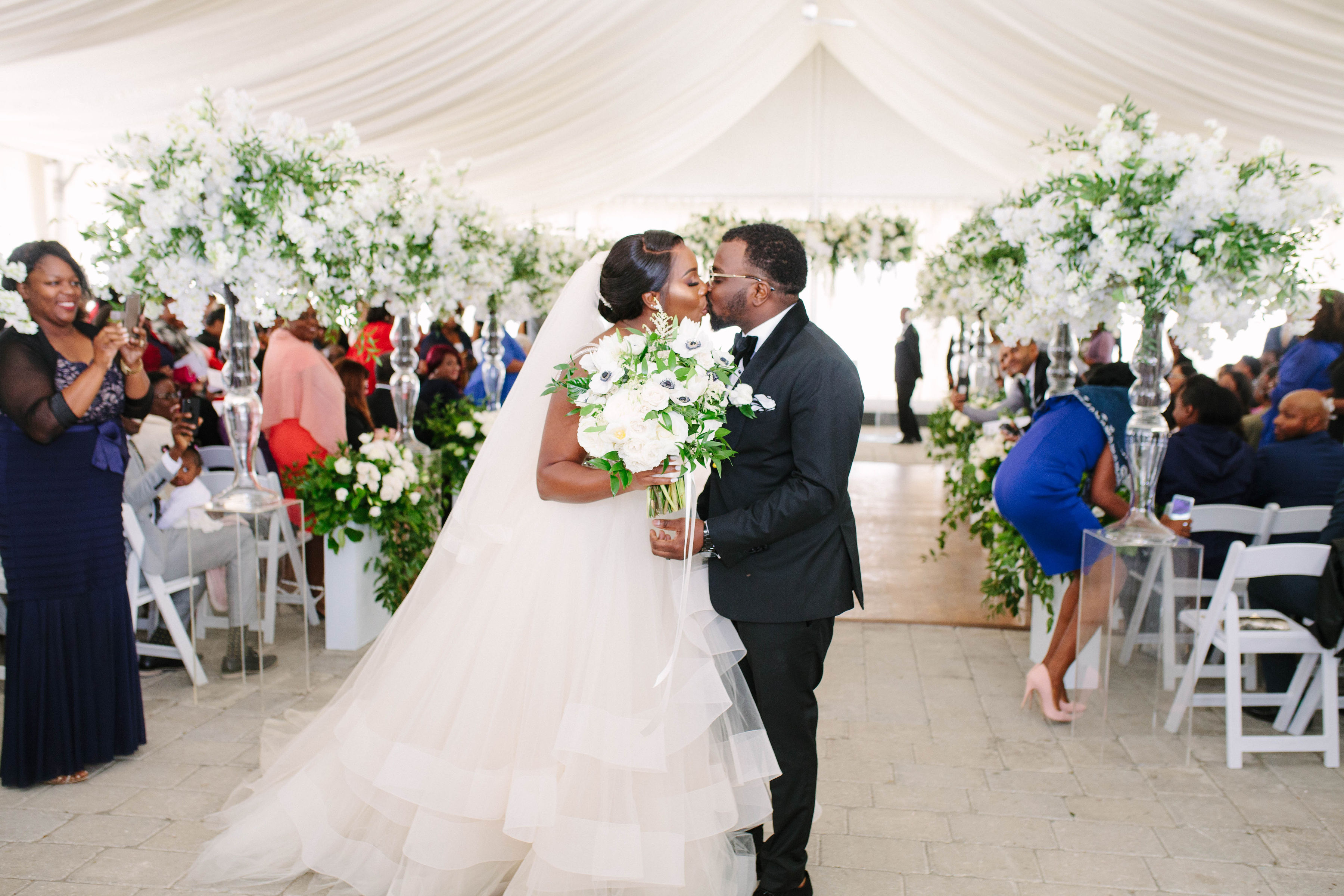 Bride and Grooms kissing at end of aisle, Toronto Wedding Photography