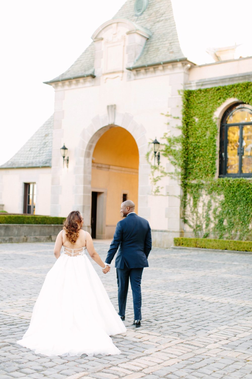 Bride and Groom walking outside of Oheka Castle, New York wedding photography.