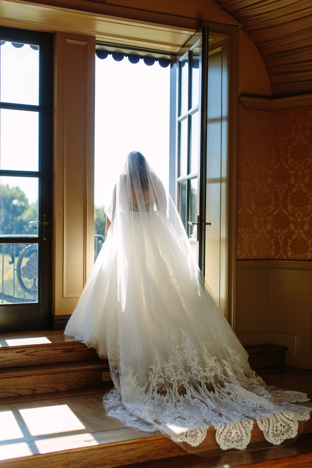 Bride looking out window at Oheka Castle.